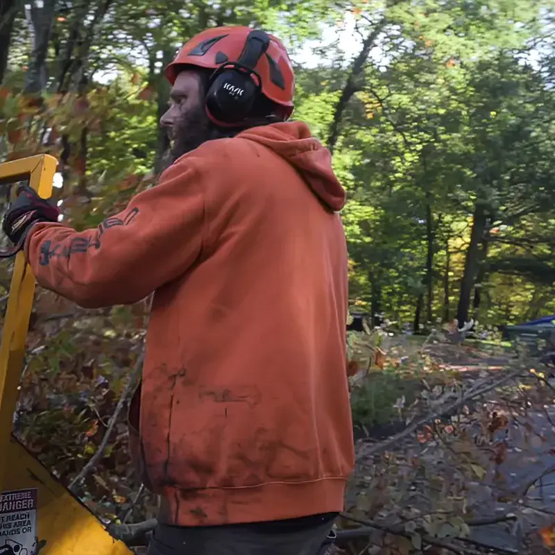 Branched Out crew member feeding brush into a wood chipper in New London County, CT