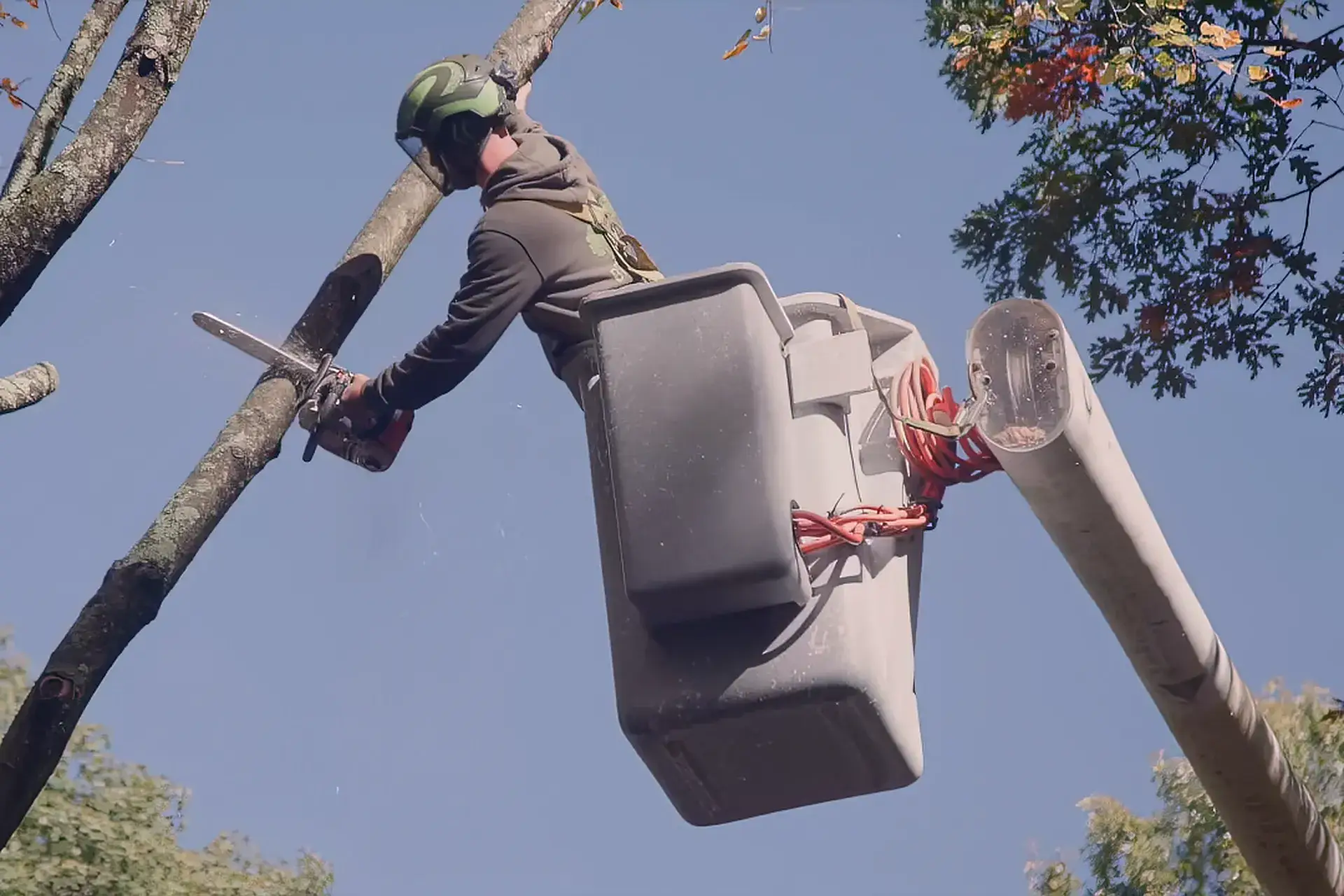 Branched Out arborist in a bucket truck cutting a limb during a tree service job in New London County, CT
